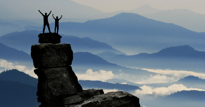 Deux personnes qui ont confiance en eux, au sommet d'une montagne